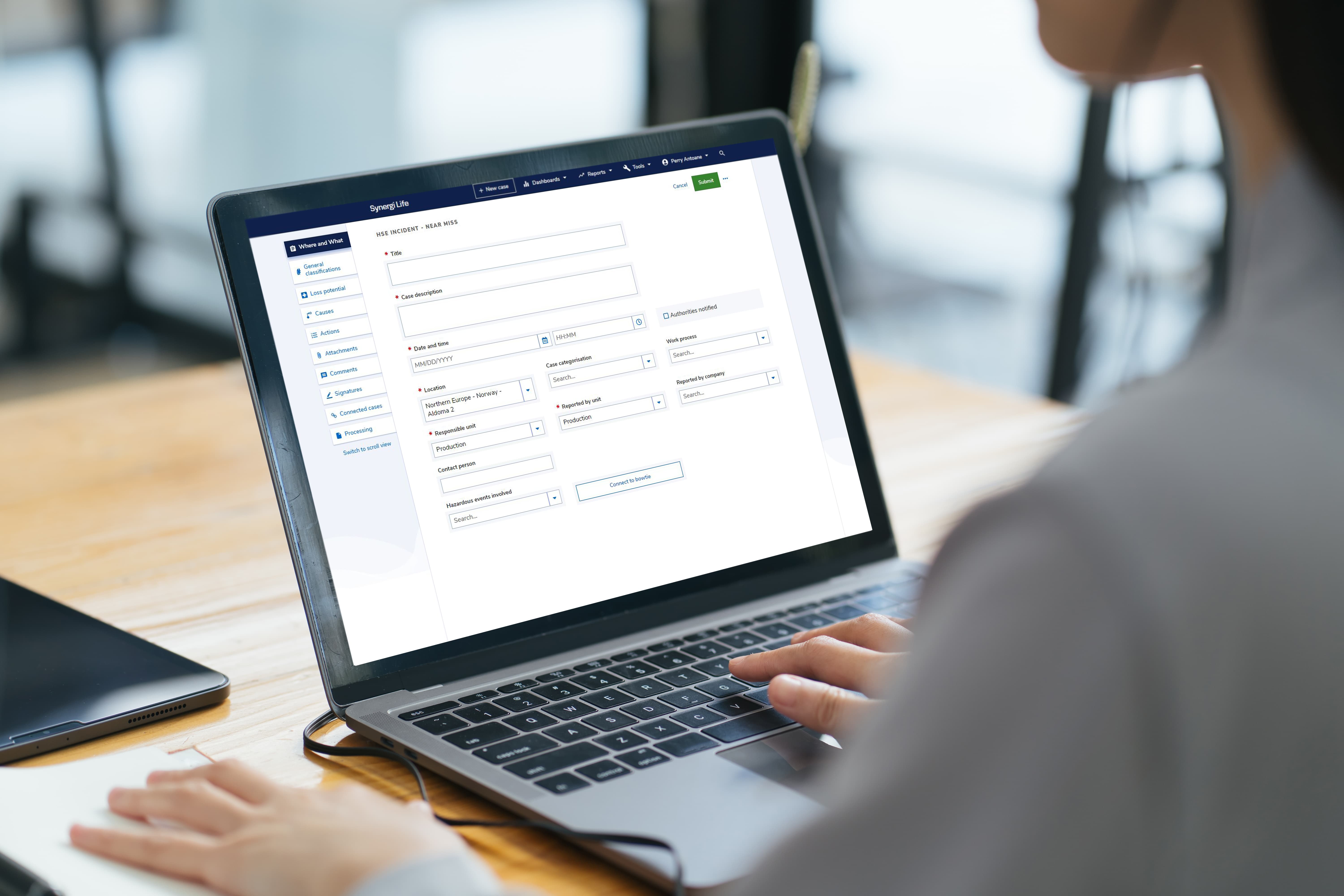 office worker uses Synergi Life software on laptop