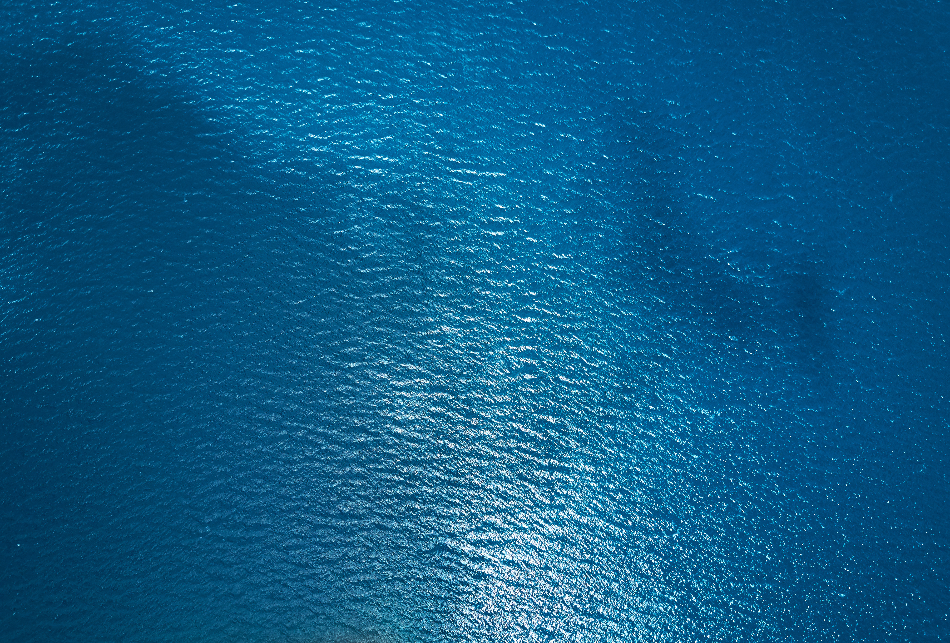 Close-up of calm blue ocean surface capturing environmental site conditions for aquaculture assessments.