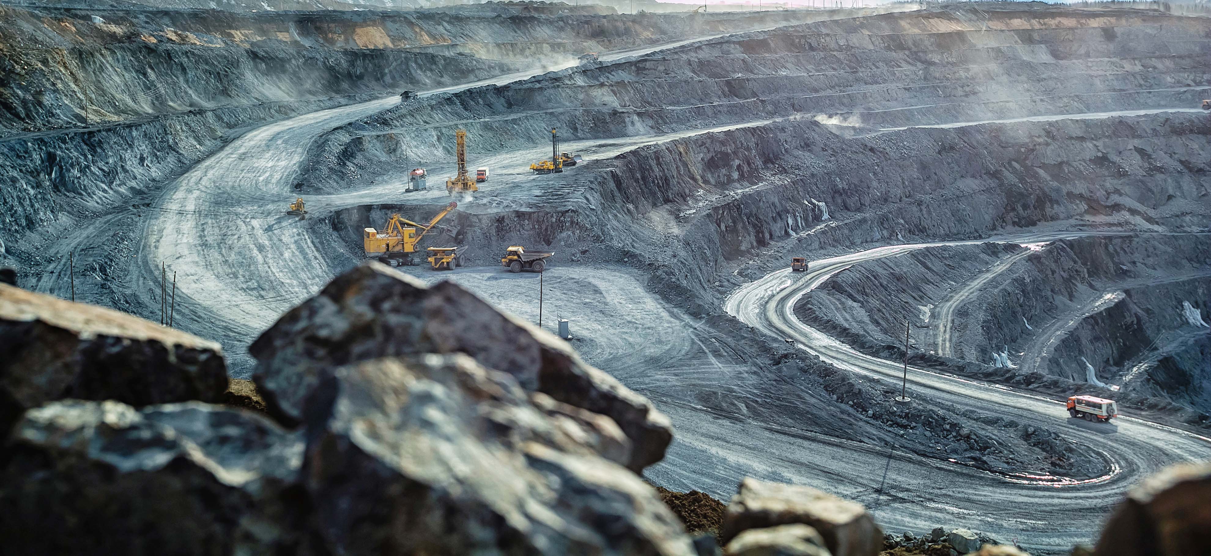 Work of trucks and the excavator in an open pit on gold mining