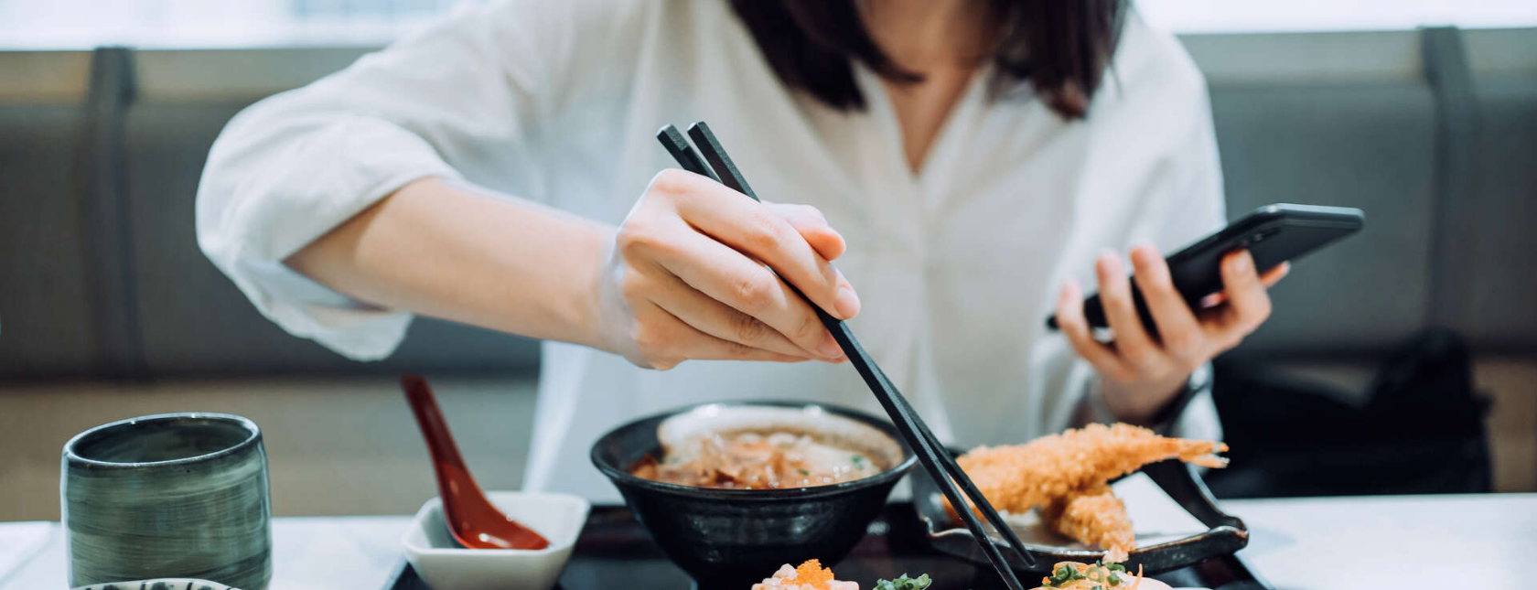 dame som spiser på restaurant med spisepinner