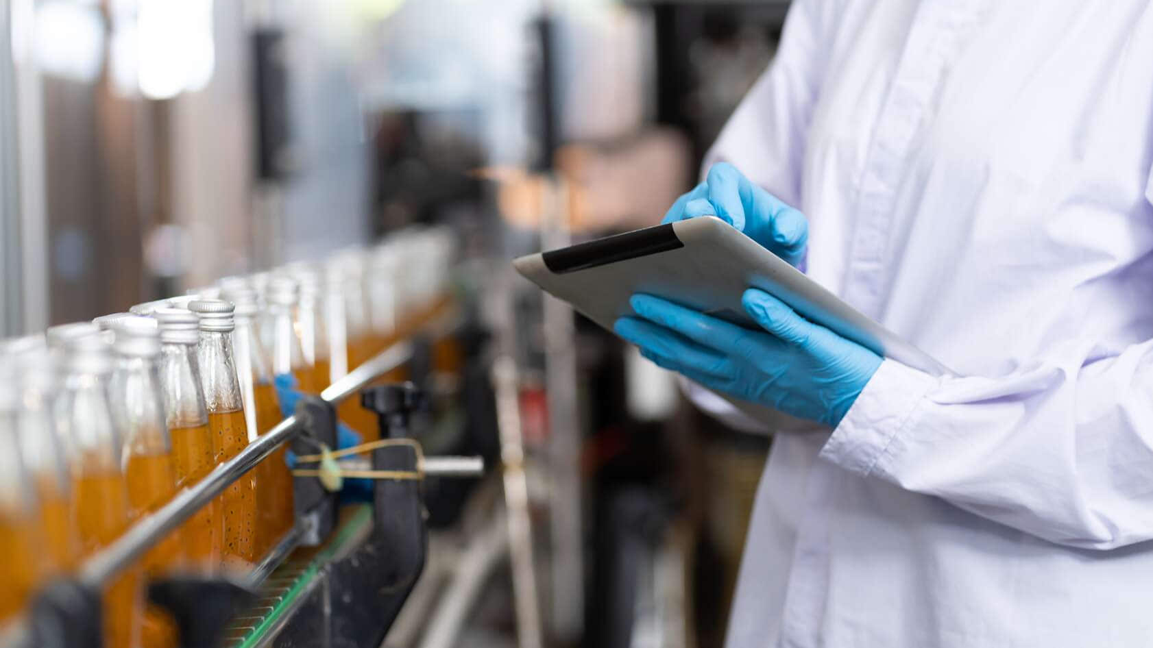 Produsent kontrollerer produktflasker