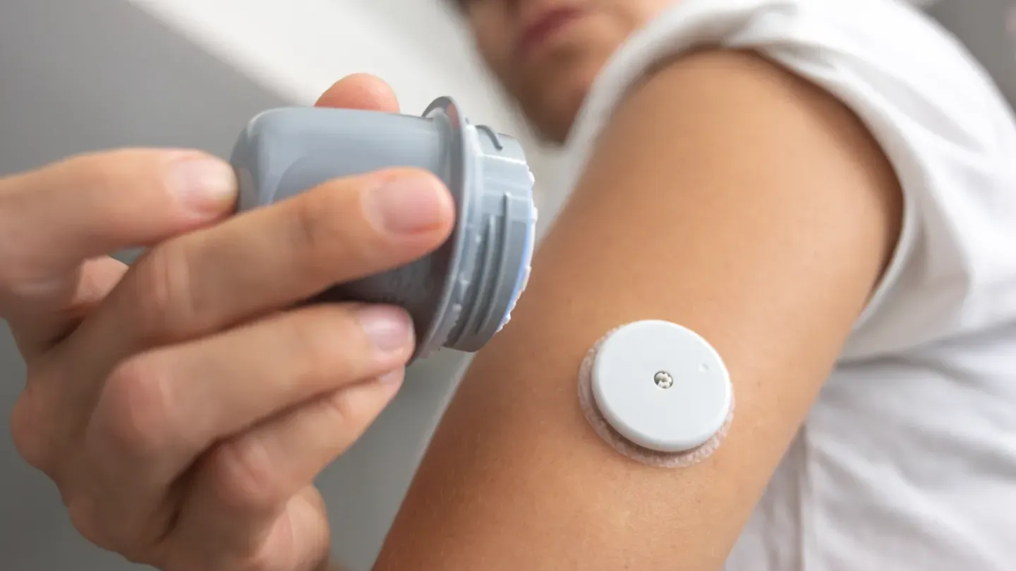 Individual applying a wearable medical sensor, highlighting UKCA requirements for general medical devices and in vitro diagnostic devices