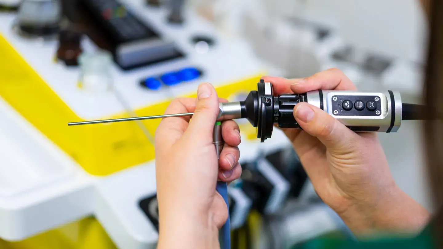Person using a digital calliper to measure a medical device component, symbolising UKCA conformity assessment and product safety verification