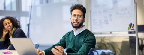 mann som snakker i møte